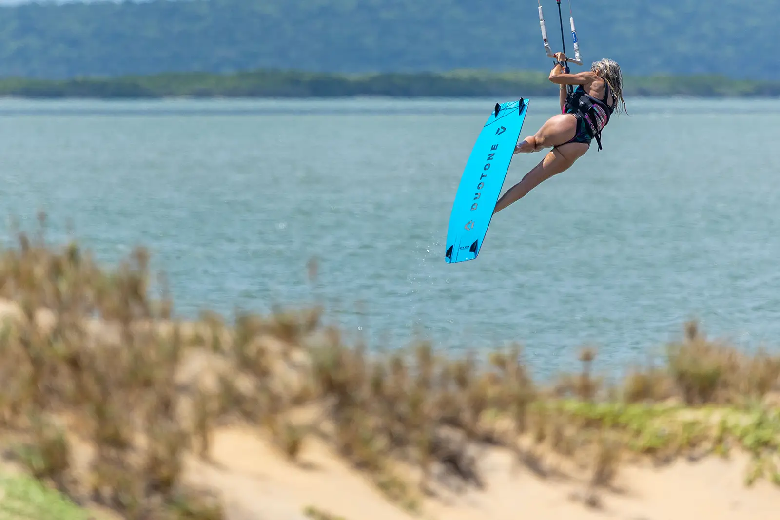 Kitesurfer in salto su laguna tropicale dello Sri Lanka con tavola Duotone durante una sessione di freestyle.